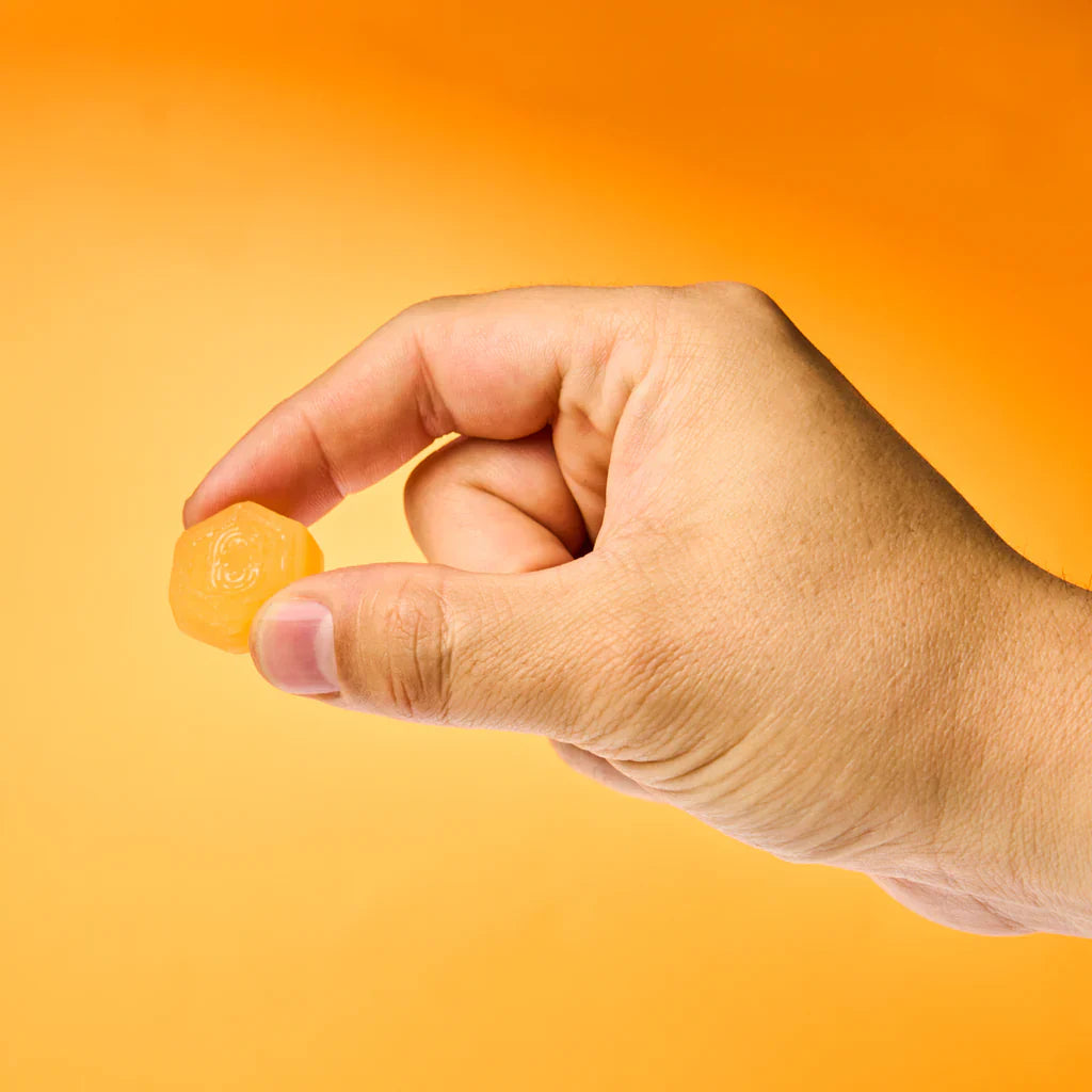 Create Creatine Gummies lifestyle shot orange gummies scattered around bag